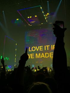 people are taking pictures with their cell phones at a music concert in front of a large screen