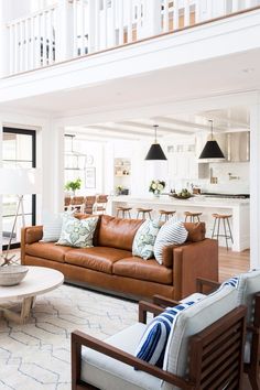 a living room filled with furniture next to a stair case in a white house on instagram