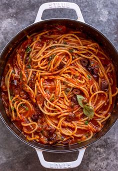 spaghetti with tomato sauce and olives in a pan