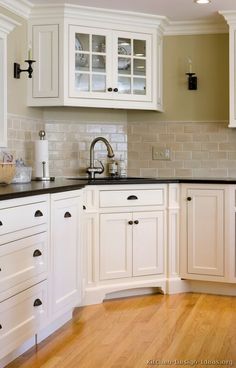 a kitchen with white cabinets and black counter tops is pictured in this image from the front view