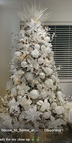 a white christmas tree decorated with silver and white ornaments