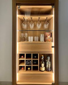 a wooden cabinet filled with glasses and bottles