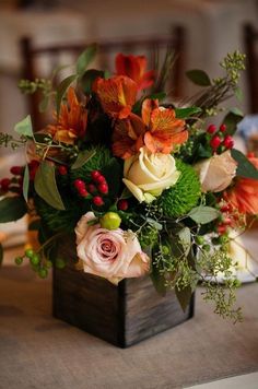 a vase filled with flowers and greenery on top of a wooden box that says wednesday