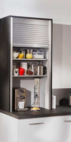 a kitchen with white cupboards and black counter tops, filled with food on top of it