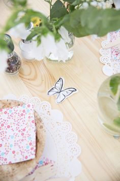 a table topped with paper doidles and vases filled with flowers