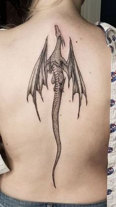 a woman with a dragon tattoo on her back