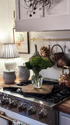 an oven with pots and pans hanging on the wall next to it's burner