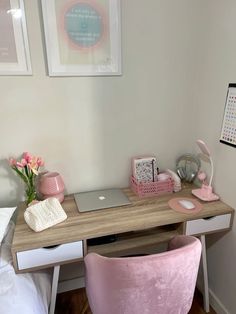 a desk with a laptop on it and pink chair next to it in a bedroom