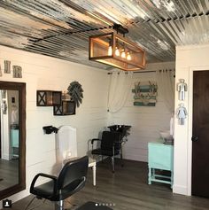 a hair salon with chairs, mirrors and lights on the ceiling in front of it