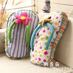 two colorful backpacks sitting on top of a white couch