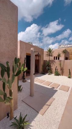 an adobe - style house with cactus trees in the courtyard