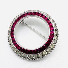 Beautiful Vintage Signed CINER Ruby Red Channel Set Rhinestone Circle Brooch. Rhodium plated metal with square cut channel set ruby red rhinestones and pave set clear rhinestone base. In excellent vintage condition with minimal age appropriate wear. Measures 1 1/8 inches across. Rollover clasp secure. Look of fine jewelry!! Luxury Red Jewelry With Channel Set, Luxury Red Jewelry Channel Set, Luxury Red Channel Set Jewelry, Vintage Designer Jewelry, Red Rhinestone, Channel Set, Square Cut, Vintage Designer, Clear Rhinestones