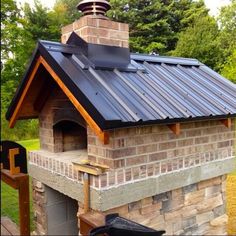 a brick oven with a metal roof and chimney