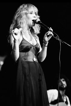 a woman standing in front of a microphone