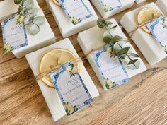 soaps with lemon slices and eucalyptus leaves tied to them on a wooden counter top