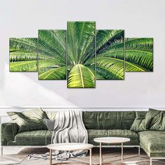 a living room with green furniture and paintings on the wall