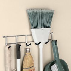 there is a broom, brush, and other items hanging on the wall