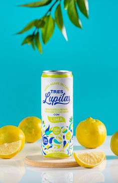 a can of lemonade sitting on top of a table next to sliced lemons