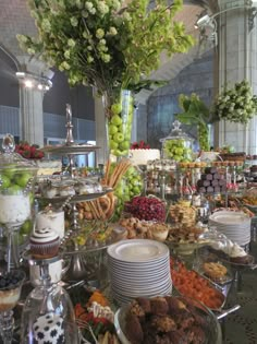 a table filled with lots of food and desserts on top of glass plates next to each other