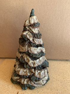 a small christmas tree made out of ruffles on a counter top with a wall in the background