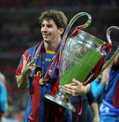 a man holding a trophy in front of him with his hands on the sidelines