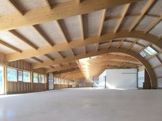 an empty room with wooden ceiling and windows