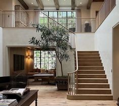 a living room filled with lots of furniture and a tree in the middle of it