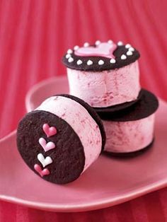 three decorated cookies sitting on top of a pink plate