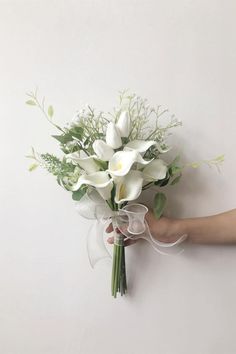 a hand holding a bouquet of white flowers