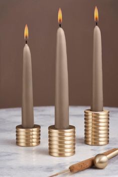 three candles sitting on top of each other with one candle in the middle and another burning