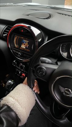 the interior of a car with a steering wheel, dashboard and display screen showing an animated video game