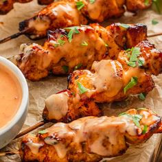 grilled chicken skewers with dipping sauce on top