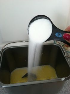 a person pouring sugar into a metal container