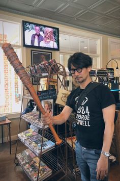 a man standing in front of a rack with a baseball bat on top of it