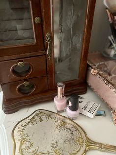 there is a mirror, nail polish and other items on the table next to it