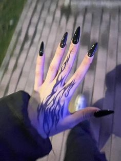 a woman's hand painted with black and blue flames