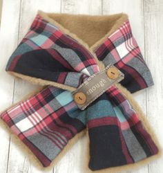 a plaid dog bow tie with a name tag on the front and back of it