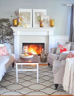 a living room with two couches and a fire place in the fireplace, surrounded by pictures on the wall