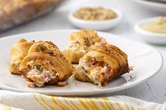 a white plate topped with pastries on top of a table next to other dishes