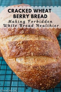 a loaf of bread sitting on top of a cooling rack with the words cracked wheat berry bread