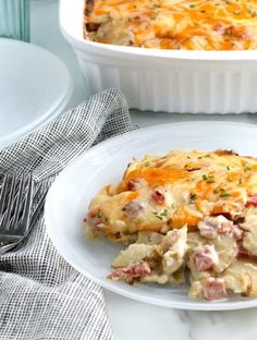 a casserole dish with ham and cheese in it on a plate next to a fork