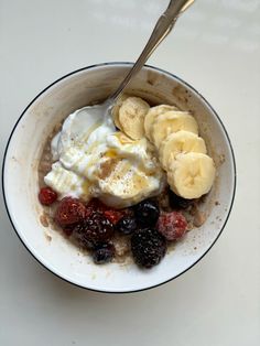 a bowl of oatmeal with bananas and berries