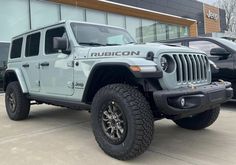 a white jeep parked in front of a building