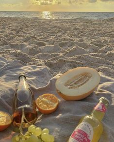 a bottle of wine and some fruit on the beach