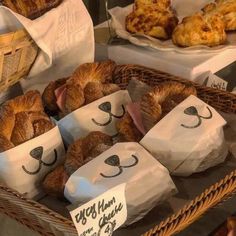 breads and pastries on display in baskets with paper bags that have faces drawn on them