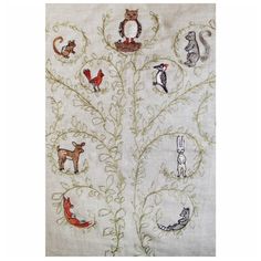 an embroidered tree with birds, cats and other animals on it's branches is shown