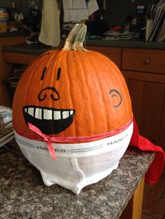 a large pumpkin with a face painted on it's side sitting on top of a counter