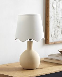 a white lamp sitting on top of a wooden table