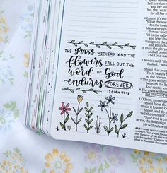 an open bible with flowers on it and the words in each book are handwritten