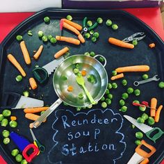 a tray with carrots, peas and scissors on it that says reindeer soup station